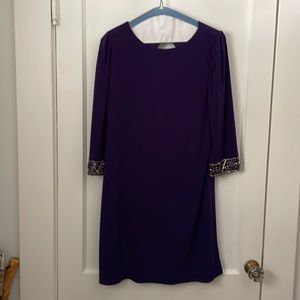 Dark purple cocktail dress. Sequin detail on cuff. Keyhole back.